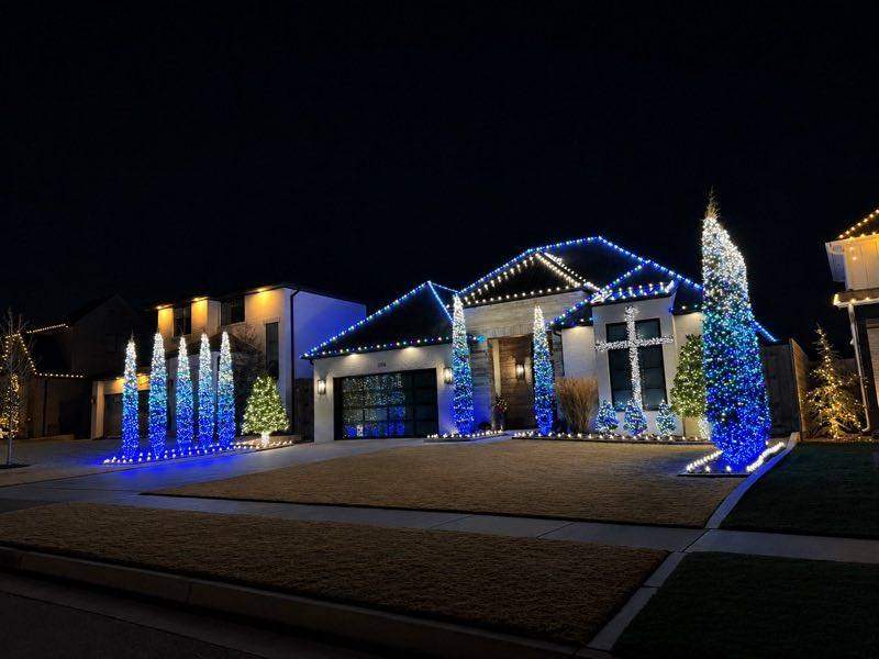 Modern home with blue and white holiday lighting and lit topiary trees, Land O' Lakes FL