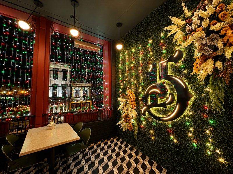 Restaurant interior decorated with string lights and greenery